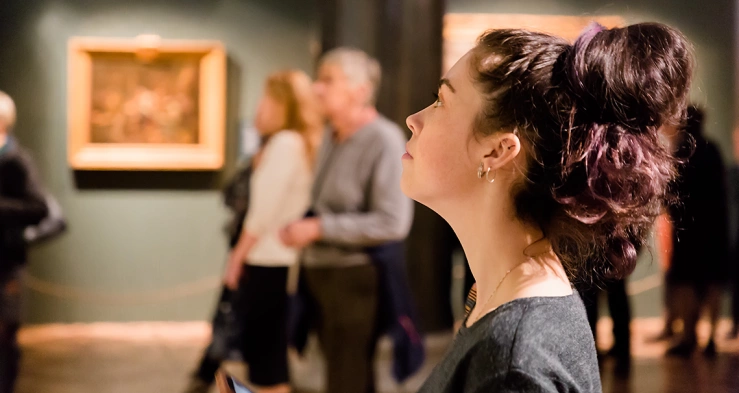 Frau betrachtet Gemälde im Museum